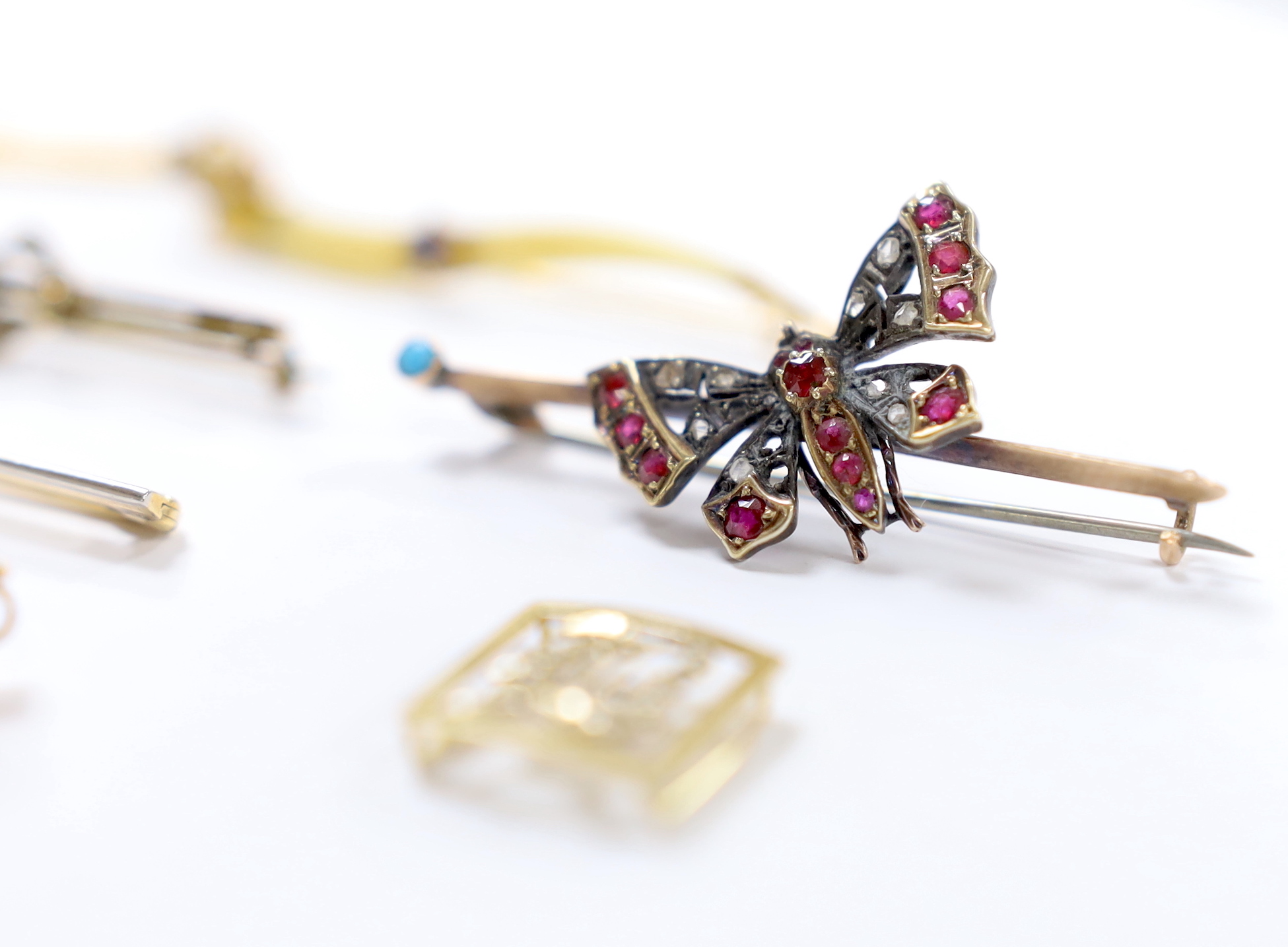 Four assorted yellow metal and gem set bar brooches, including a ruby and diamond four stone set, 56mm and a Victorian yellow metal, rose cut diamond and gem set butterfly bar brooch, together with two pairs of ear studs